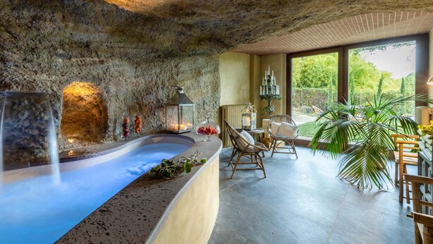 A spa area with a hot tub, seating, and a view of greenery. - Il Conte Farmhouse Retreat (Castelfranco di Sotto)