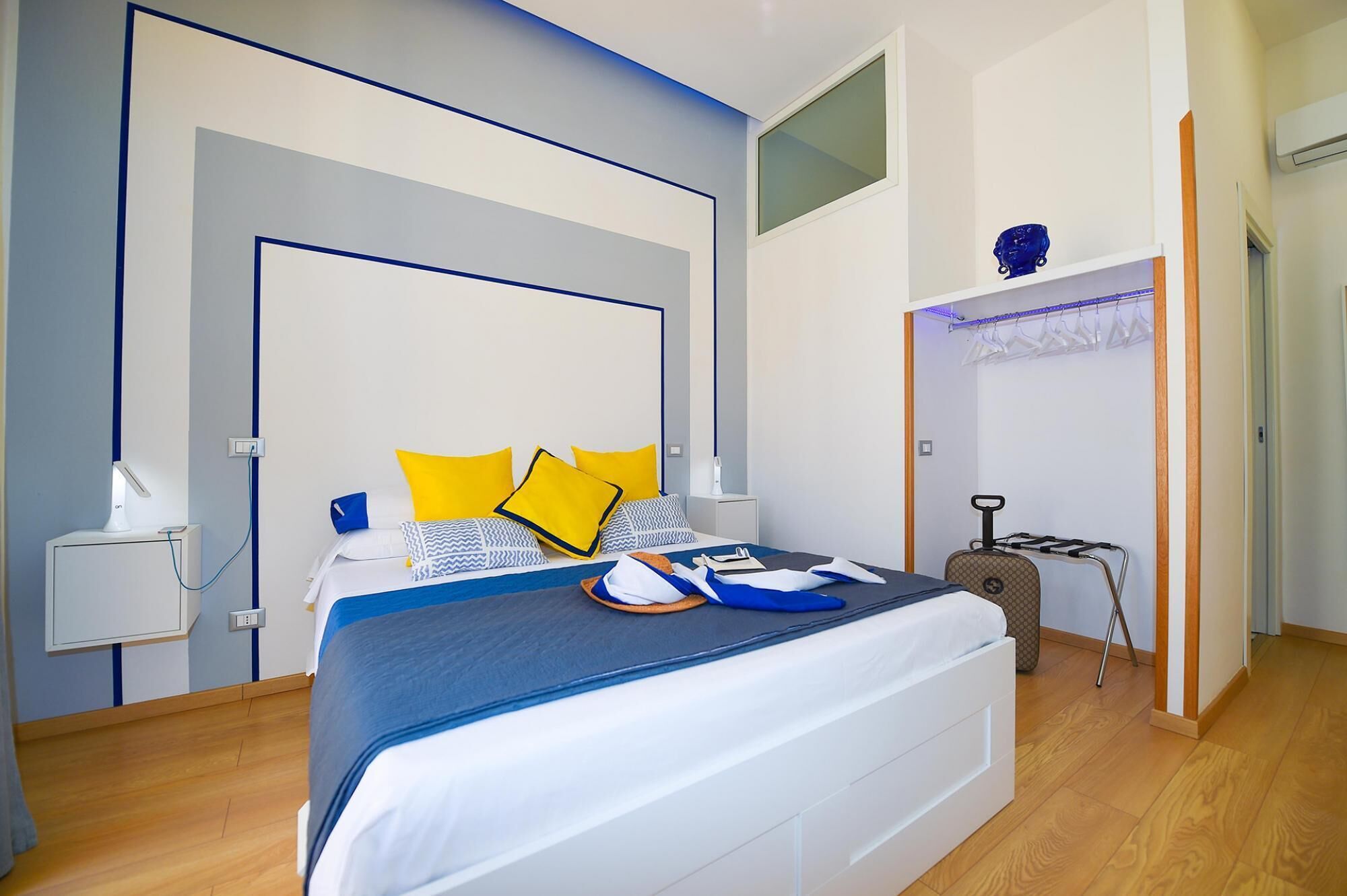 Un dormitorio moderno con una cama, mesitas de noche, un armario y un tendedero.