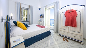 A bedroom with a bed, a bedside table, a wardrobe, and a view of the outdoors. - Maison Don Rafe in Positano (Positano)