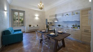 Une cuisine moderne avec une table à manger, des chaises et un lustre.