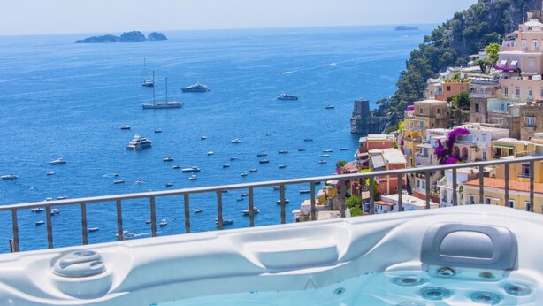 Un bain à remous avec vue sur la mer et les bâtiments côtiers.