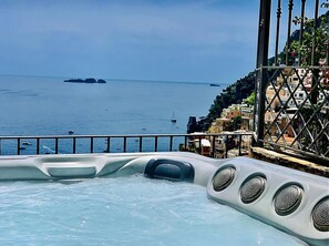 Uma banheira de hidromassagem com vista para o mar e edifícios à beira-mar.