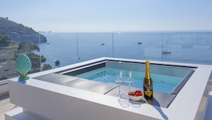 A modern outdoor pool area with a clear view of the sea and boats. - Villa Iside in Nerano (Massa Lubrense)