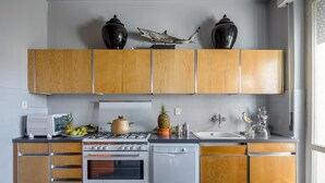 A kitchen with wooden cabinets, a stove, a dishwasher, and a sink. - La Casa Matta in Viareggio (Viareggio)