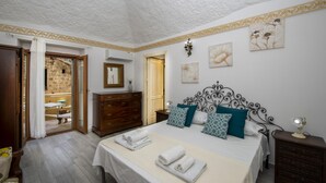 A bedroom with a bed, a dresser, a mirror, and a door leading to a balcony. - Amore Rentals - Casa Barbera B (Positano)