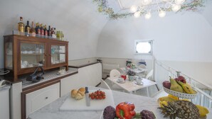 Une cuisine dotée de meubles en bois, d’un plan de travail en marbre et d’un coin repas avec une table mise pour deux personnes.