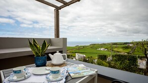 A balcony with a table set for tea, a potted plant, and a view of the countryside. - Tradicampo-Cycas-Casa da Cisterna- Romantic little corner - NEW LISTING (Algarvia)