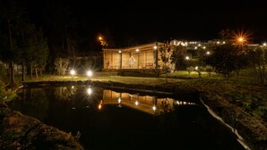 A building with a pond in front, surrounded by trees and illuminated by multiple lights. - Tradicampo-Cycas-Casa da Cisterna- Romantic little corner - NEW LISTING (Algarvia)