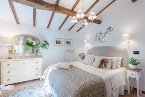 Un dormitorio con cama, cómoda y mesitas de noche.