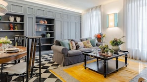 A living room with a grey sofa, a wooden coffee table, and a checkered floor. - Gimber Tales a First Floor Apartment (Lucca)