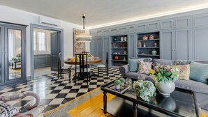 A modern living room with a checkered floor, grey cabinets, a sofa with patterned cushions, and a coffee table with decorative items. - Gimber Tales a First Floor Apartment (Lucca)