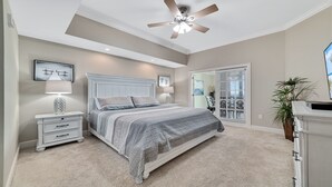 A bedroom with a bed, nightstands, a ceiling fan, and a view of the outside through a window. - New Owner, New to the Rental Market, Lazy River/Slide!! (Orange Beach)