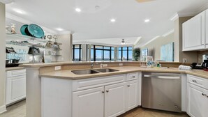 A modern kitchen with a large island, built-in appliances, and a view to the outside. - New Owner, New to the Rental Market, Lazy River/Slide!! (Orange Beach)