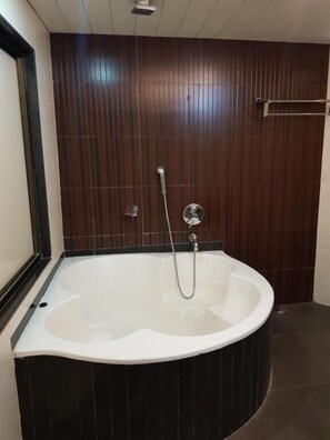 Un baño moderno con una bañera independiente, ducha y toallero.