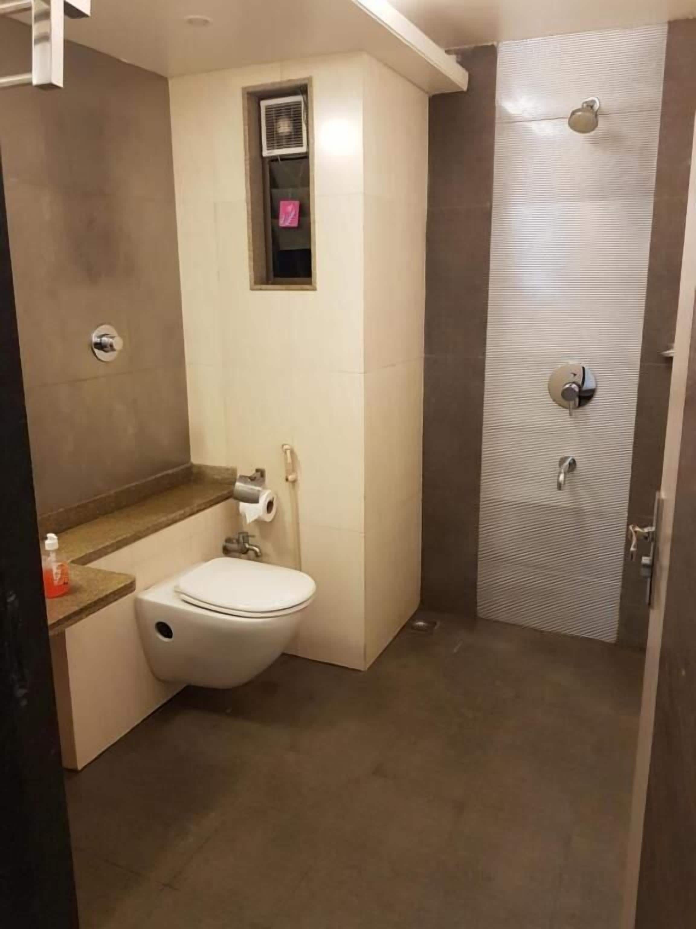 Une salle de bain avec des toilettes, un lavabo et une cabine de douche.