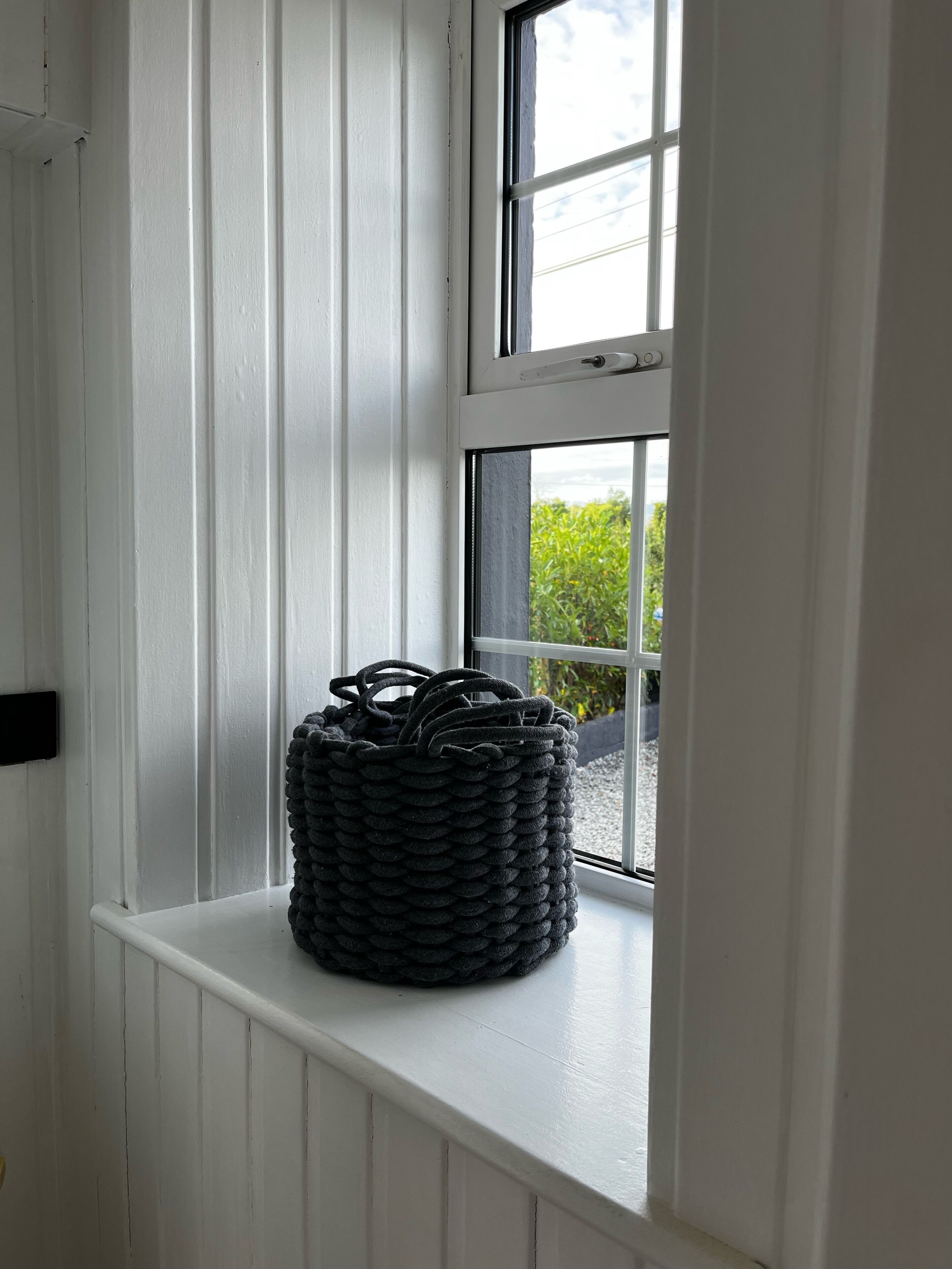 A window with a woven basket on the sill.