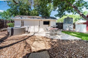 Relax in the patio area with a hot tub, seating and a charming storage building.