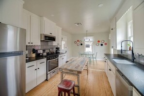 Enjoy cooking in this well-equipped kitchen with a central island, sink, and dining area.