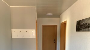 A hallway with a tiled floor, a white ceiling, and a door at the end. - Beautiful holiday apartment on the Moselle (Piesport)