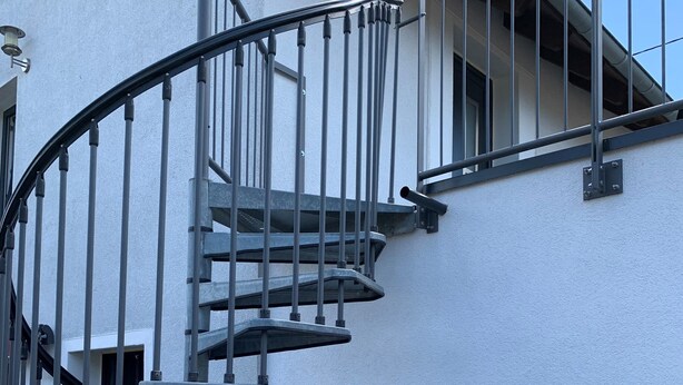 A spiral staircase with metal railings against a white wall, leading to an upper floor. - Beautiful holiday apartment on the Moselle (Piesport)