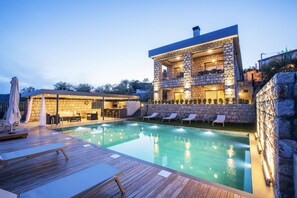 A modern house with a swimming pool, stone exterior, and outdoor seating area. - Trio'da Kazdaglari (Ayvacik)
