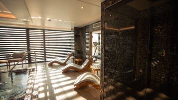 Relax in a serene spa area with a glass-enclosed shower and comfortable lounge chairs.