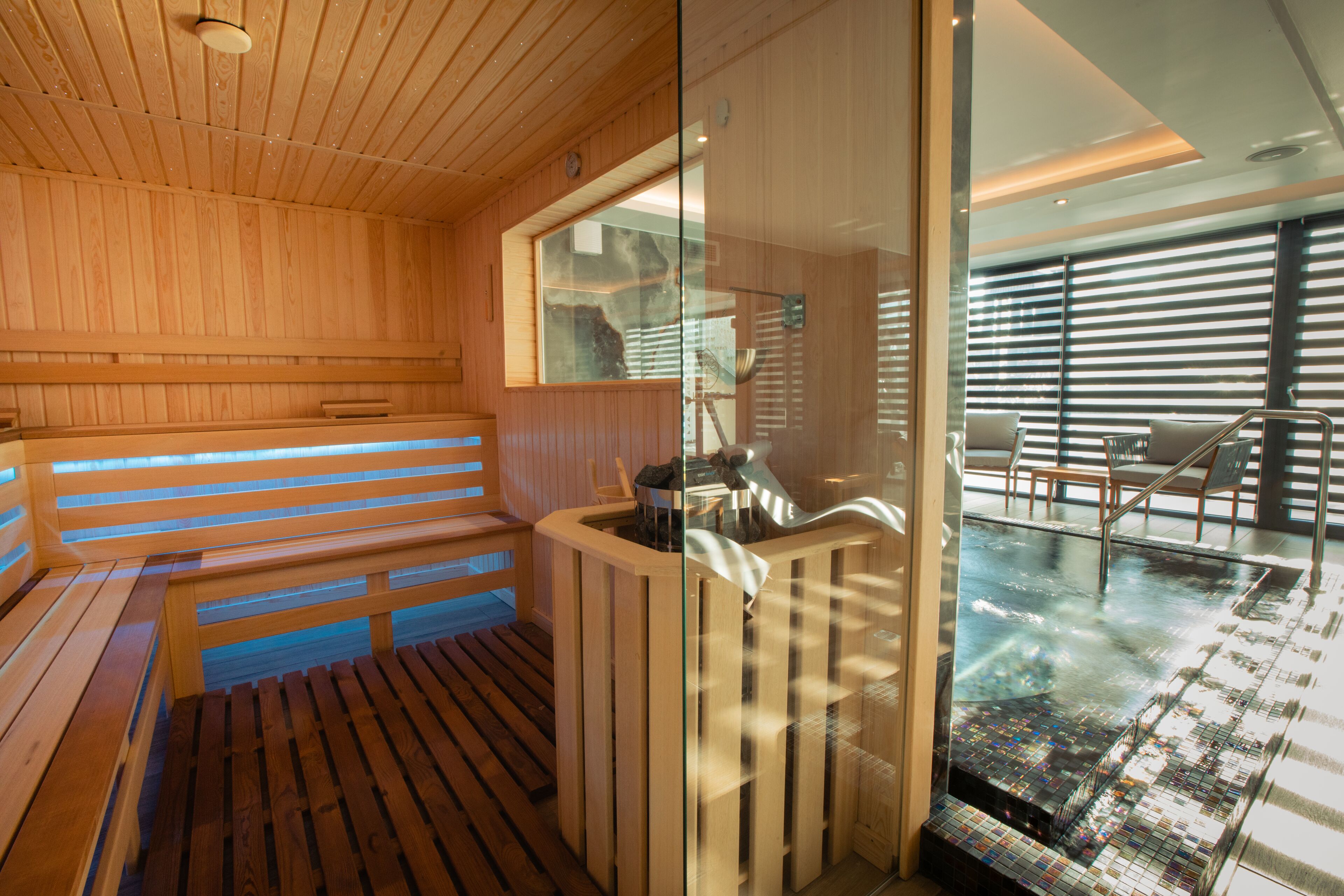 A sauna with wooden benches and a glass partition.