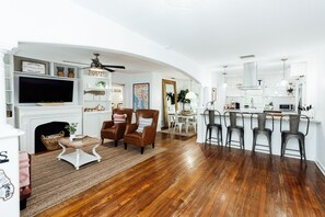 A spacious living area with a fireplace, a television, and a dining area with bar stools.