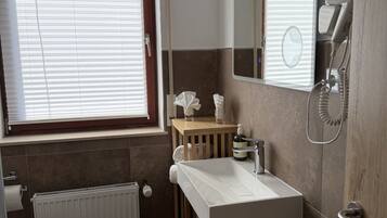 A bathroom with a toilet, sink, and shower.