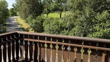 A wooden bridge with a tiled walkway, surrounded by greenery and trees.