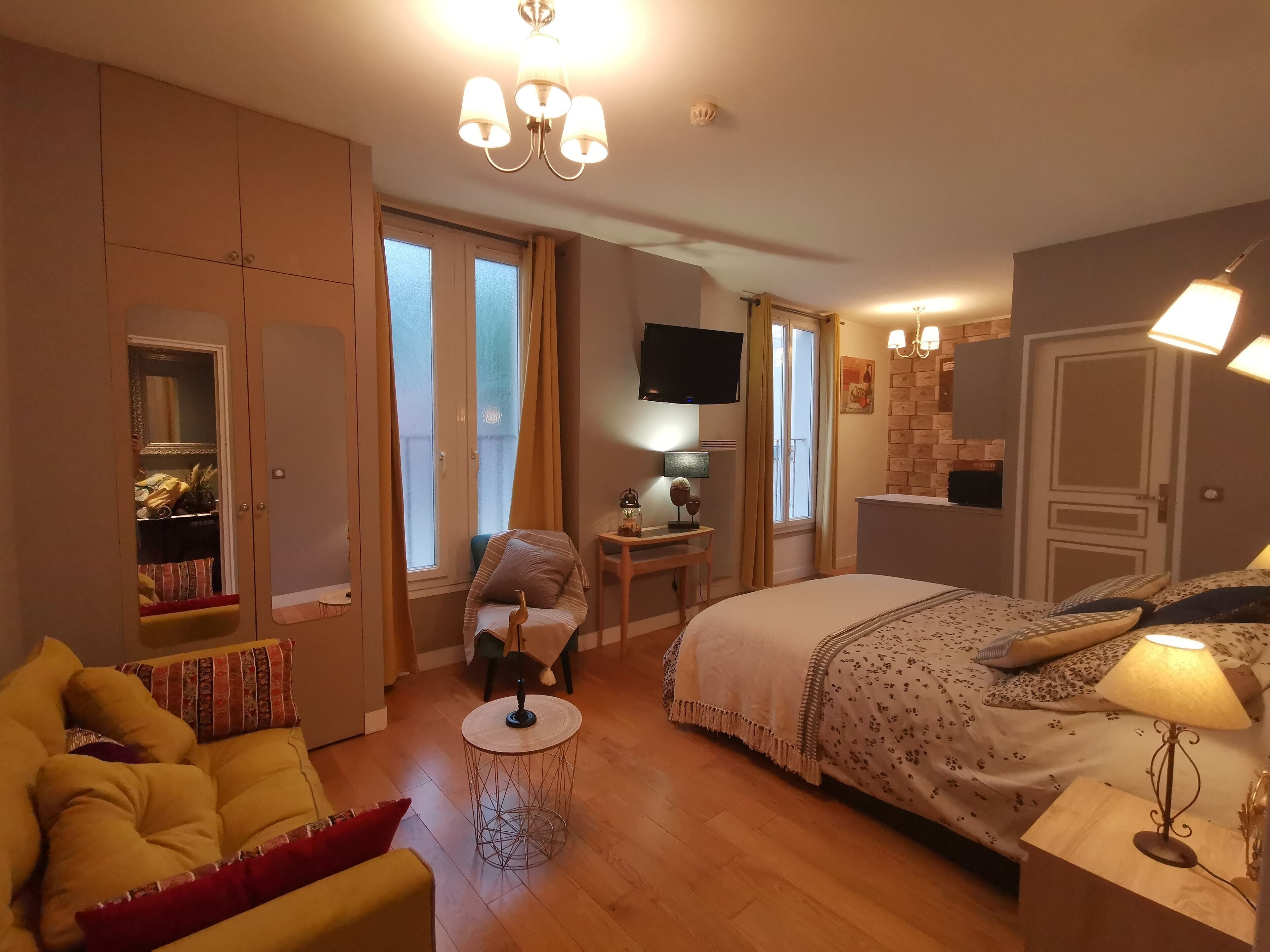 Une chambre à coucher comprenant un lit, un bureau, une chaise, un canapé et un téléviseur.
