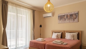 Habitación de hotel con una cama grande, una lámpara en el techo, un aire acondicionado y un cuadro en la pared.