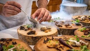 A chef preparing food on a wooden board with various ingredients. - Antique İasos Butik Otel (Milas)