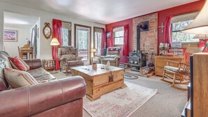 A cozy living room with a leather sofa, a wooden chest, and a rocking chair. - Cozy Creekside Cabin in La Veta: Hike & Fish! (La Veta)
