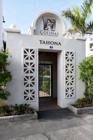 A building entrance with a sign reading 'COLINAS DE LOS MENCIEYES' and 'TAHONA' above the door.