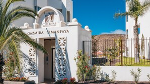 A white building with a sign reading "Colinas de los Menceyes" and "Gazmira Timanfaya". - Colinas - Gazmira 2.1 DELUXE 2B (Arona)