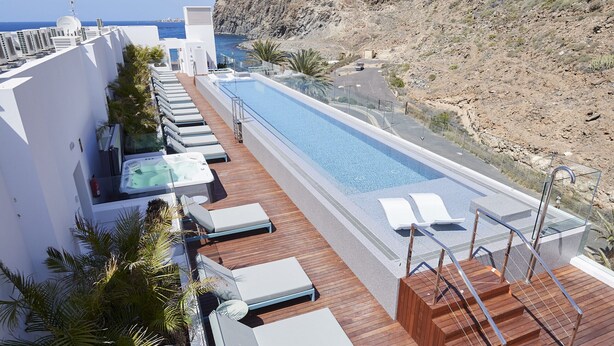 A rooftop pool area with lounge chairs, a hot tub, and a view of the sea. - Infinity 0.3 LUXE PARTIAL SEA VIEW 2B (Arona)