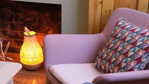 A cozy seating area with a cushioned chair, a small table, and a decorative lamp.