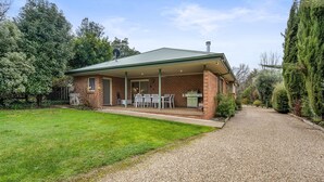A brick house with a covered patio, a barbecue area, and a gravel driveway. - The Parkers - in the Heart of Bright (Bright)