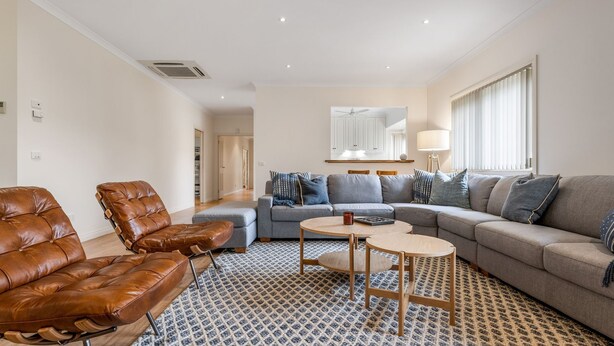 A modern living room with leather armchairs, a grey sofa, and a patterned rug. - The Parkers - in the Heart of Bright (Bright)