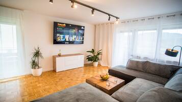 Appart'hôtel Luxe | Coin séjour | TV connectée de 85 pouces avec chaînes par satellite, télévision