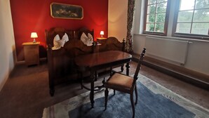 Una habitación con una cama de madera, dos lámparas de noche, una mesa y una silla.