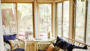 A sunroom with a ceiling fan, wicker furniture, and a 'Welcome Home' sign. - Cabin's entire, private lower level w/ mountain view & cozy, comfortable living. (Colorado Springs)