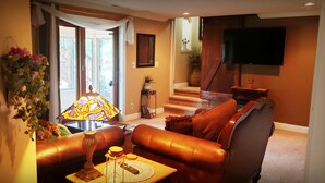 A living room with a sofa, a lamp, and a television. - Cabin's entire, private lower level w/ mountain view & cozy, comfortable living. (Colorado Springs)