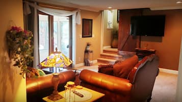 A living room with a sofa, a lamp, and a television.