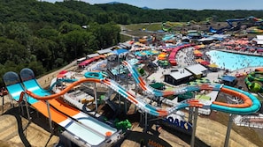 A water park with multiple slides and pools, surrounded by trees.