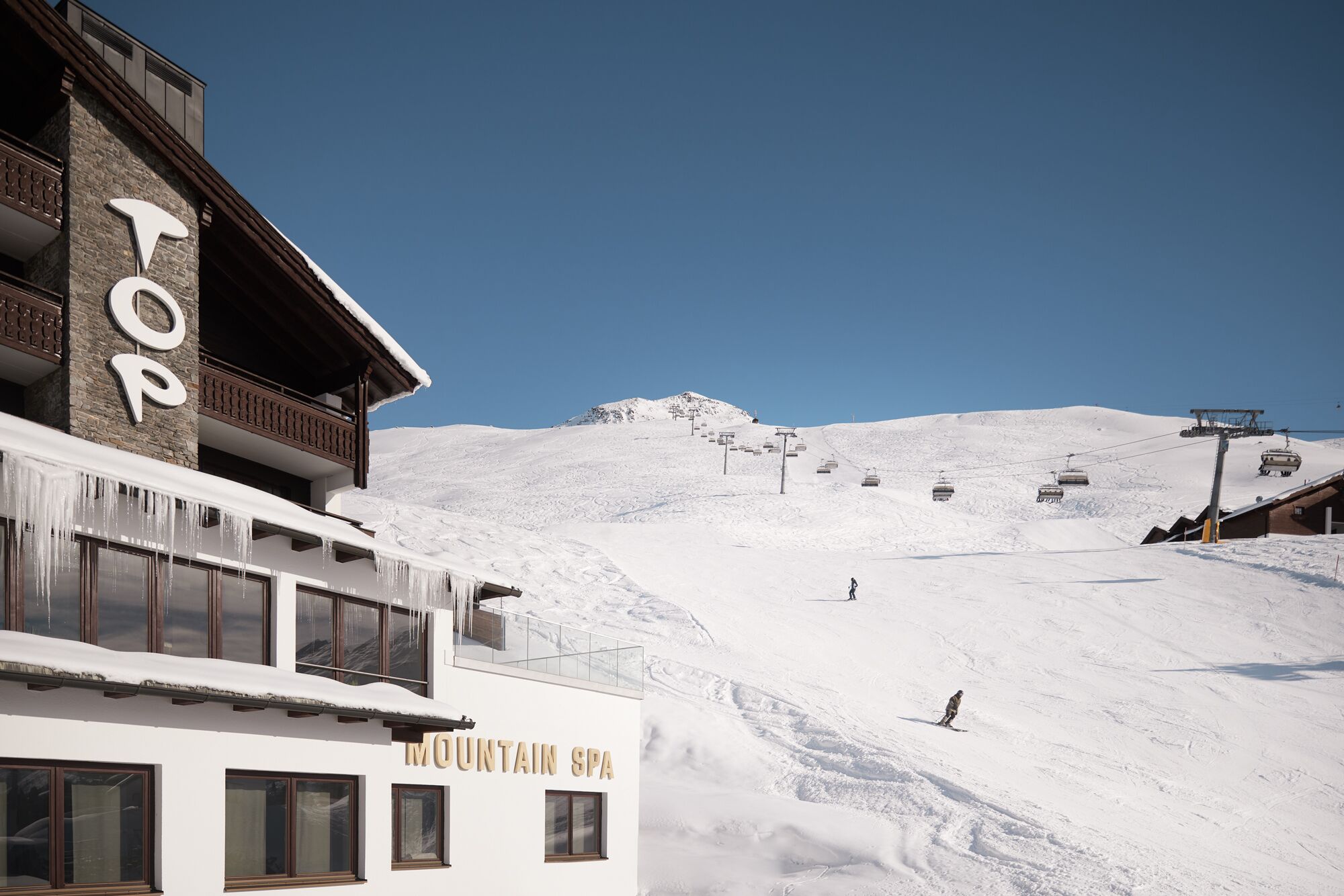 A snow-covered mountain with a ski lift and a building labeled "MOUNTAIN SPA".