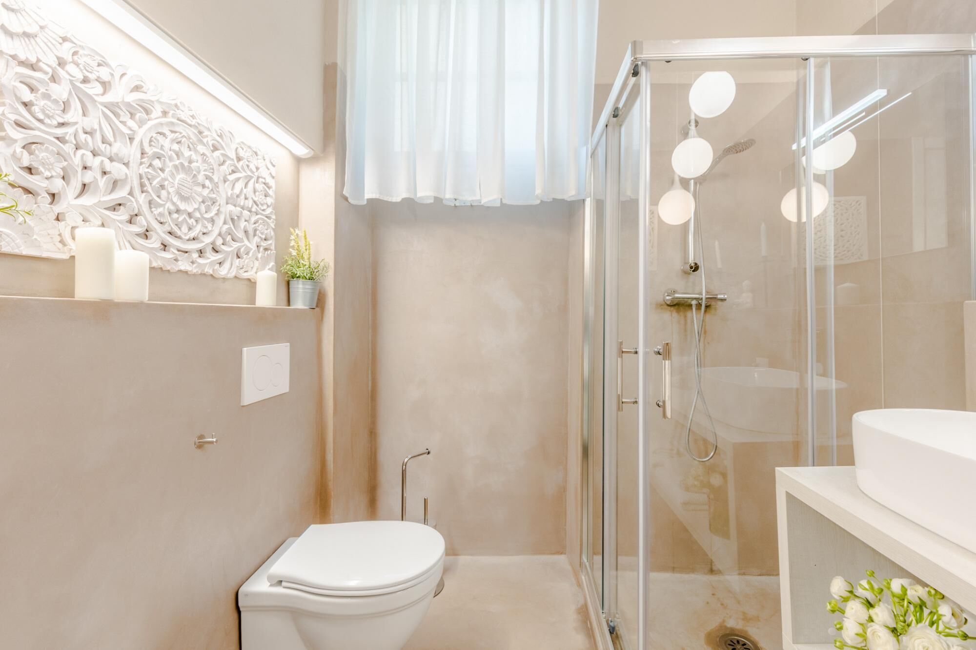 A modern bathroom with a glass-enclosed shower, a toilet, and a vanity with a sink.