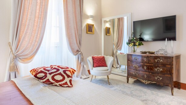 A bedroom with a bed, a dresser, a TV, and a mirror. - The Silk Thread the Luxury 3 Bedrooms Apartment (Lucca)