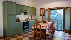 Una cocina con armarios verdes, piso a cuadros y una mesa de comedor con sillas.